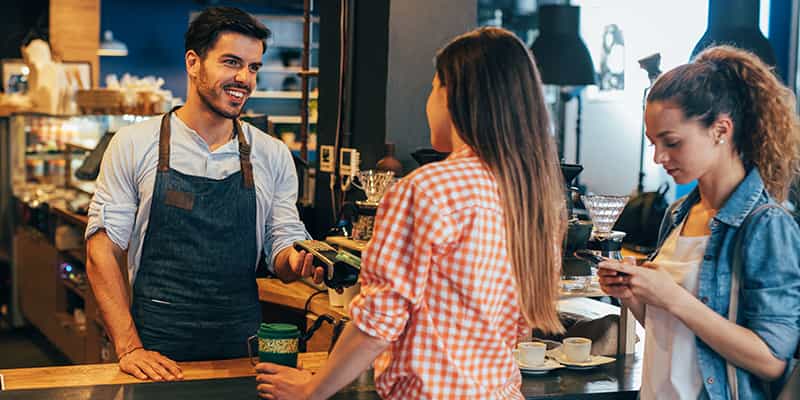 Lethbridge retail property owner interacts with customers at a cash register in a cafe